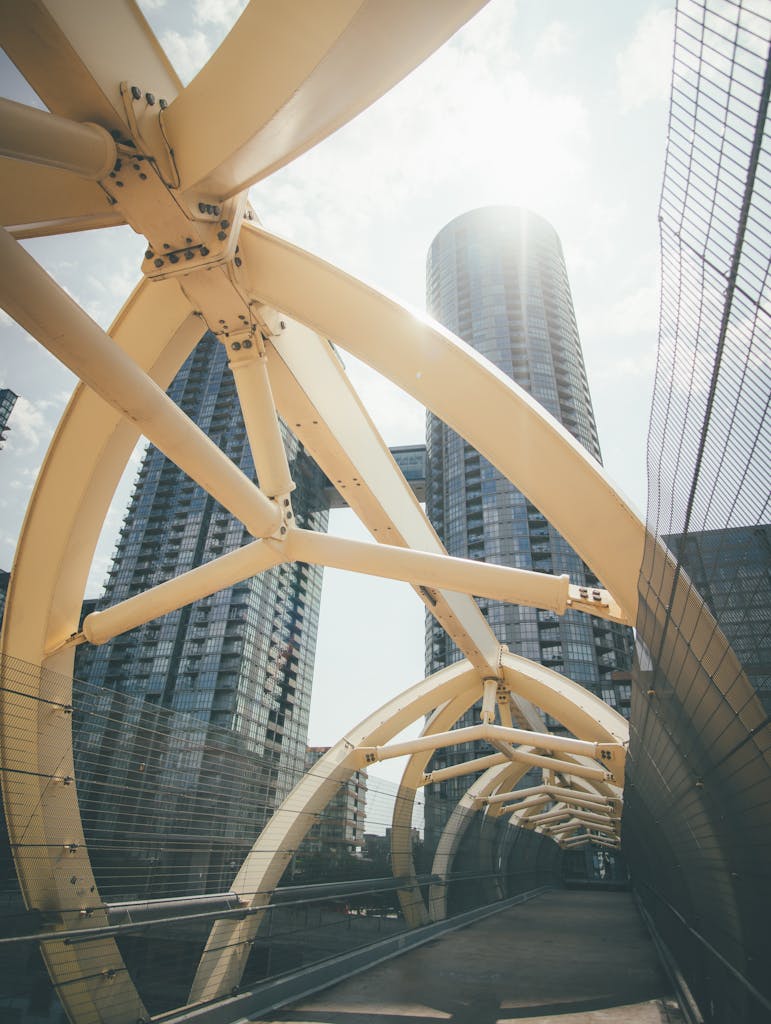 Modern bridge with skyscrapers in a cityscape under bright daylight.